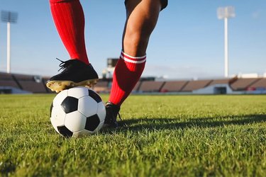 Cropped image of a persons legs playing football