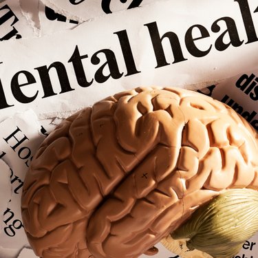 Image of a brain with mental health headlines surrounding