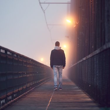 Person walking away along a bridge