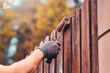 Person painting fence