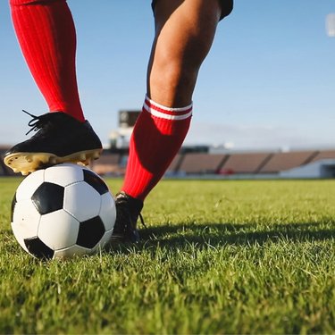 Cropped image of a persons legs playing football